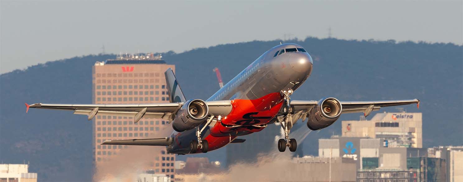 Jet taking off over city buildings